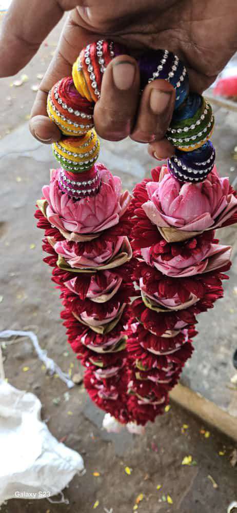 Red rose garlands topped with pink lotus, on colourful silk-thread bead hangers.