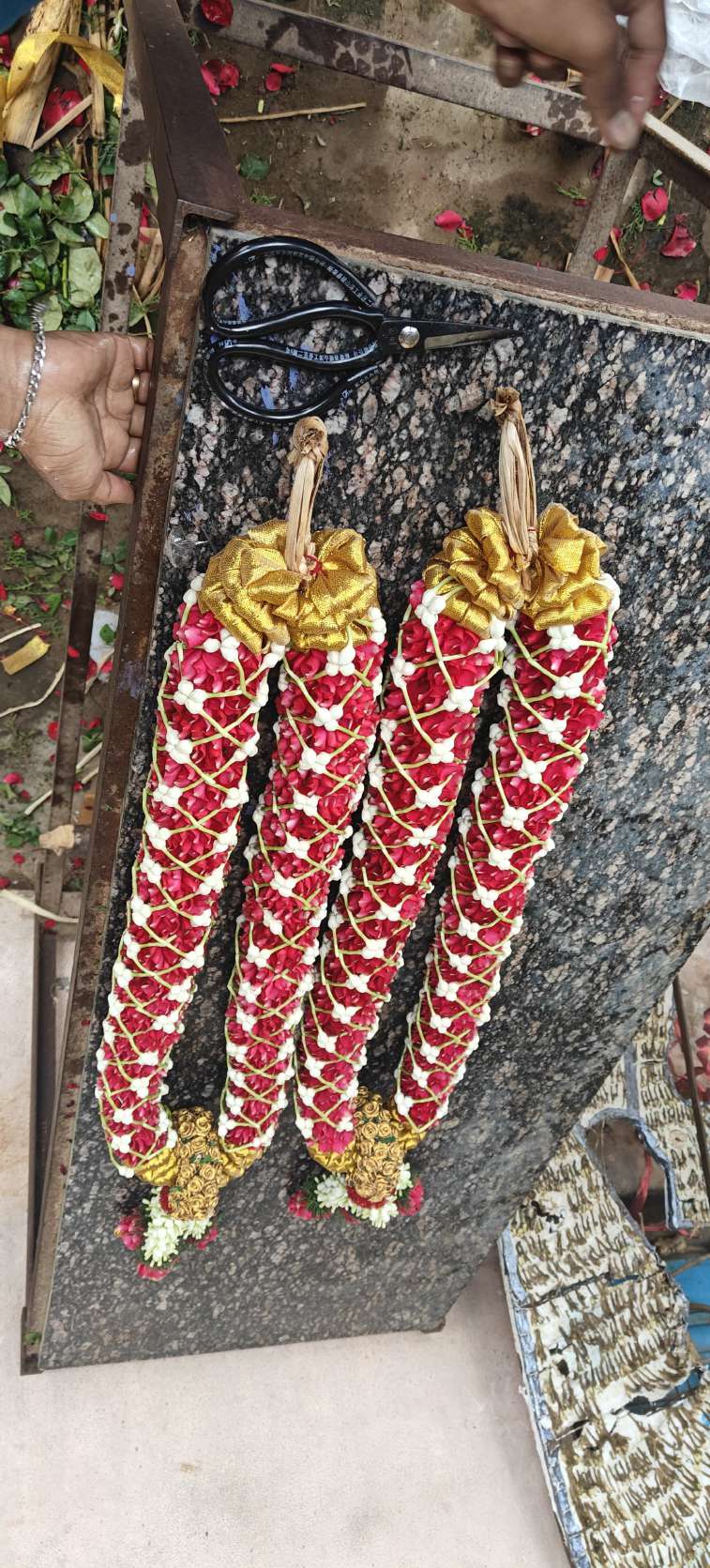 Pair of red garlands with a white chevron pattern and gold bow tops, against a granite slab.