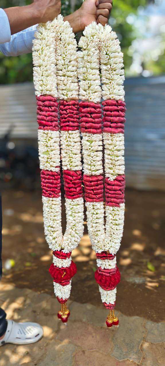 White hanging garlands with broad red floral bands and red and gold-coloured tassels.