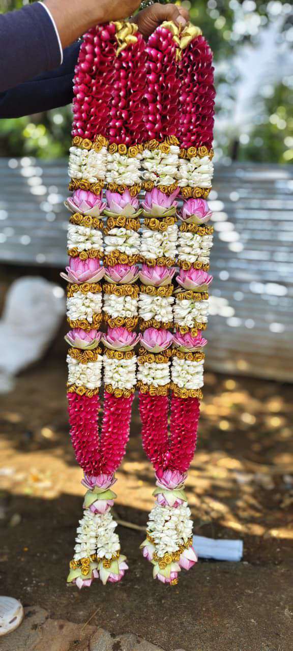 Pair of garlands with red rose sections, pink lotus and white-and-gold bands, and lotus tassels.