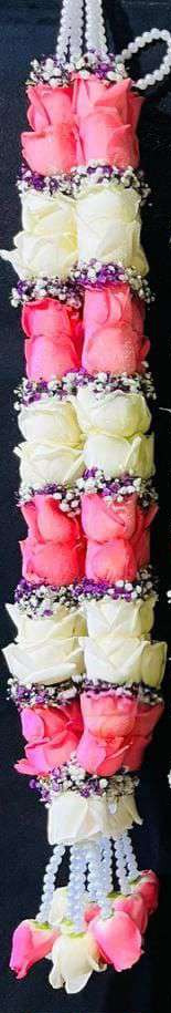 Garland of alternating pink and white rose blocks edged with purple baby's breath, with pearl hangers.