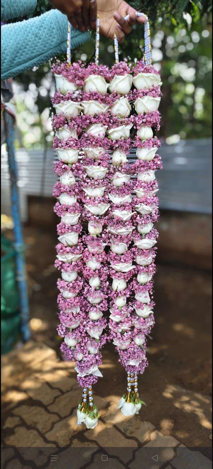 Pair of white rose garlands wrapped in lavender baby's breath, with white pearl hangers and white rose tassels.
