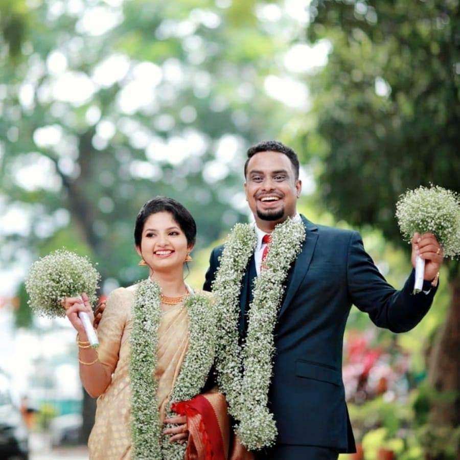 Thick baby's breath garlands worn by a couple holding baby's breath bouquets.