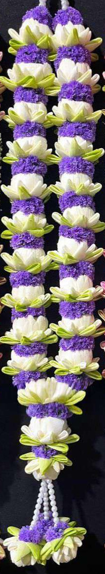 Garland alternating white lotus and purple statice, with pearl hangers and lotus tassels.