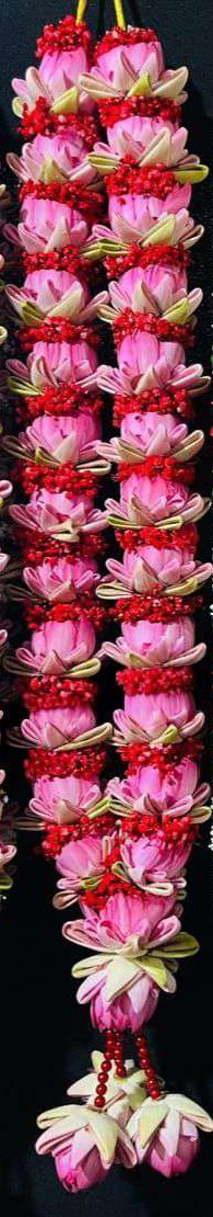 Pink lotus garland with red accents between the blooms, red bead hangers and lotus tassels.