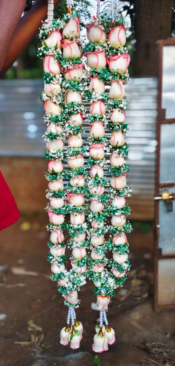 Pair of pink-edged white rose garlands with green leaves and baby's breath, pearl hangers and rose tassels.