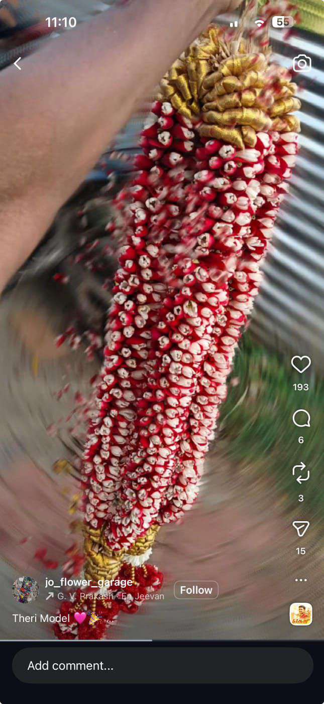 Dense red-and-white bud garland with a gold rosette top, shown in a phone screenshot.