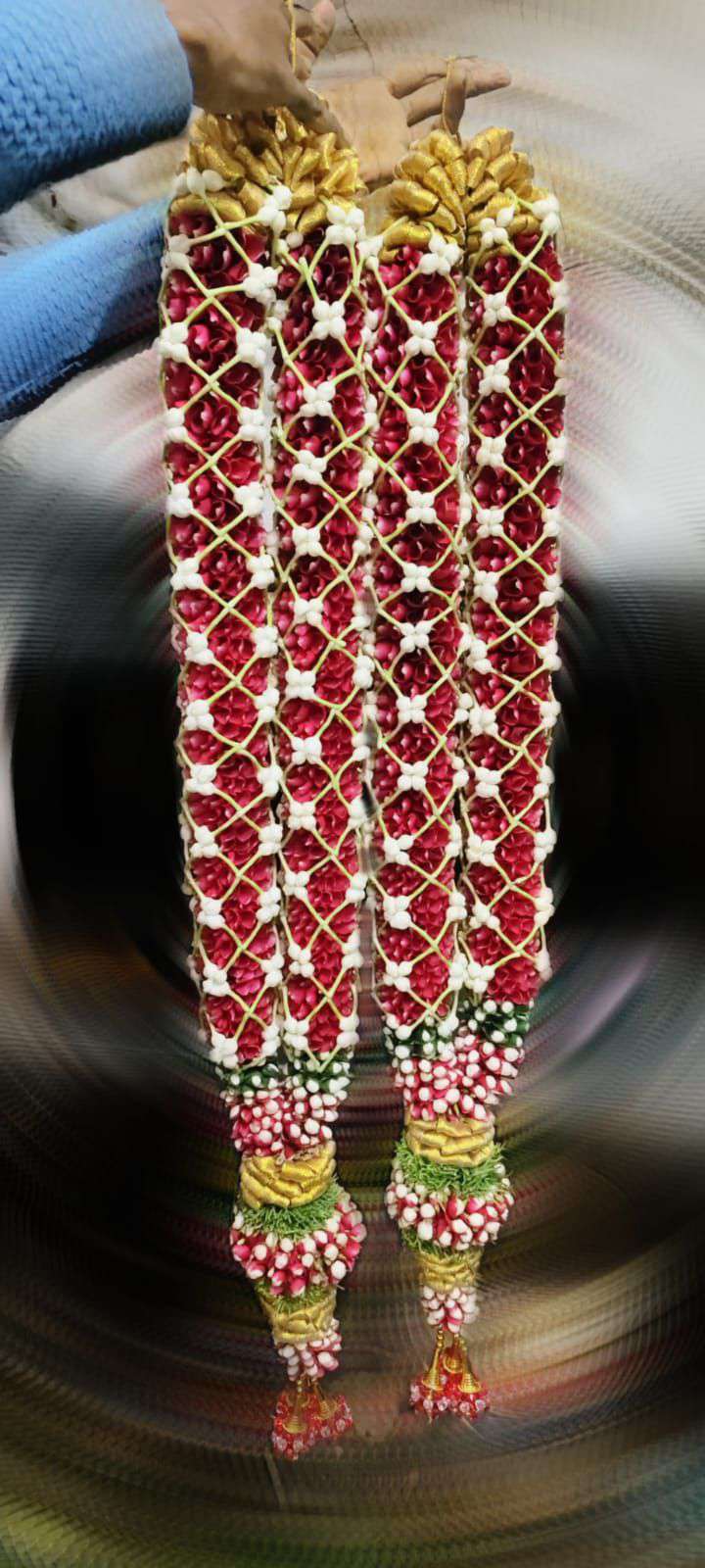 Red floral garlands covered with white lattice detailing, gold-coloured top sections and decorative tassels.