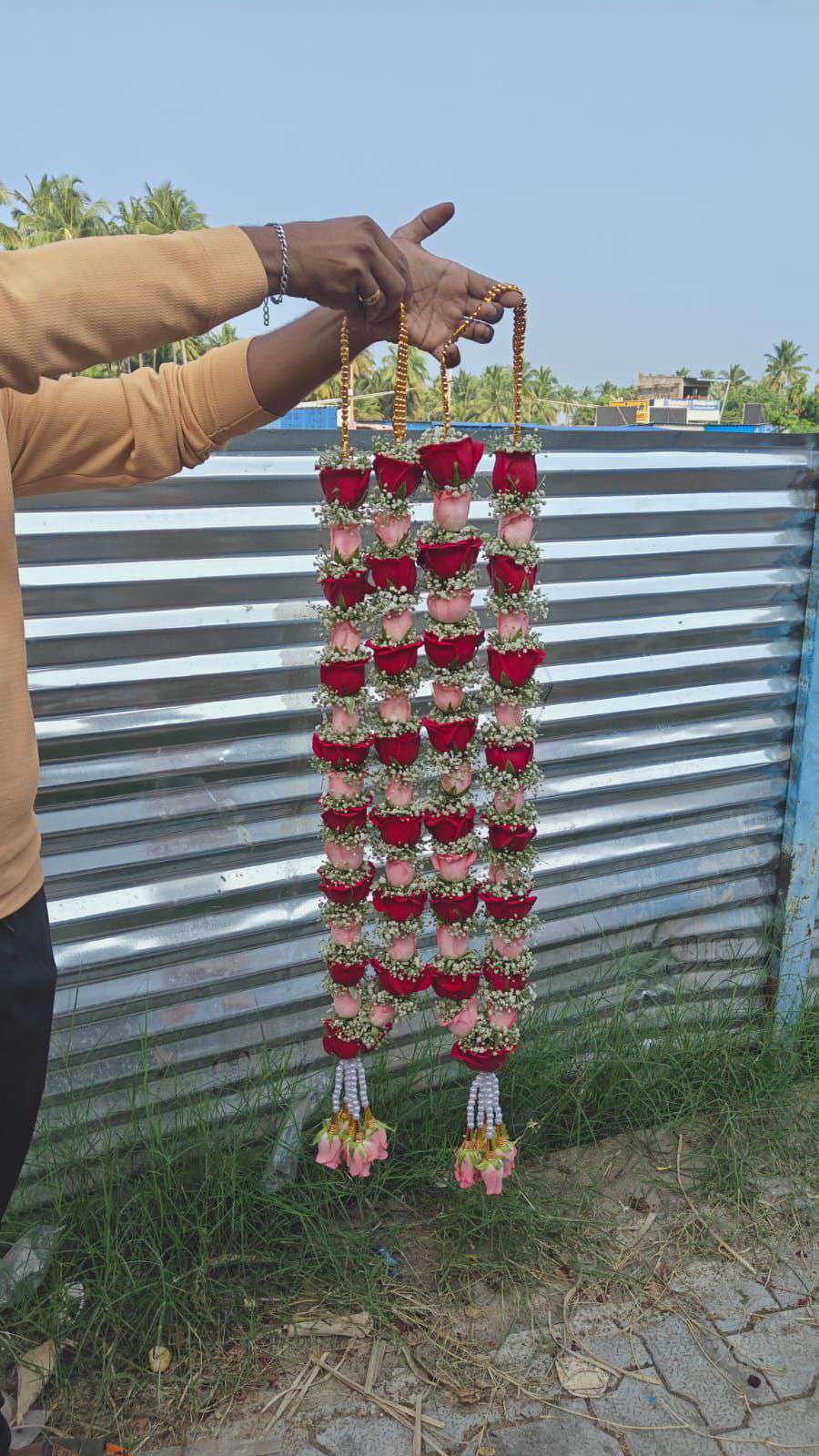 Pair of slim red rose garlands with pink accents, gold bead hangers and pale pink tassels.