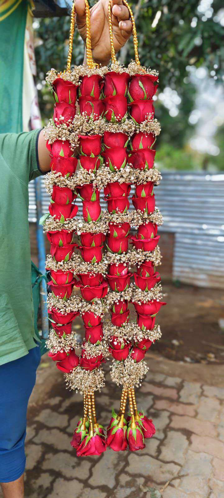 Pair of red rose garlands banded with golden-toned baby's breath, with gold bead hangers and red rose tassels.