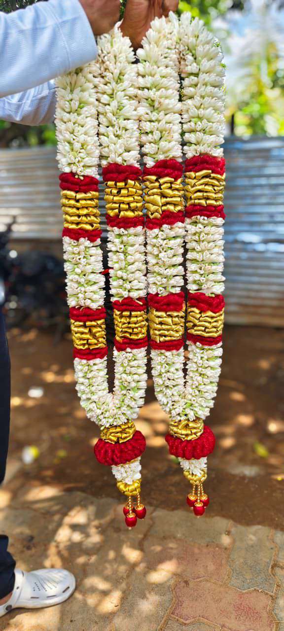 White garlands with red and gold-coloured bands and matching tassel details.