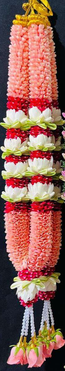 Coral bud garland with white lotus and red bands, pearl strands and pink rose tassels.