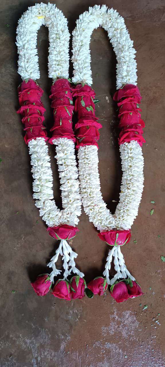 White looped garlands with large pink rose sections and pink flower tassels.