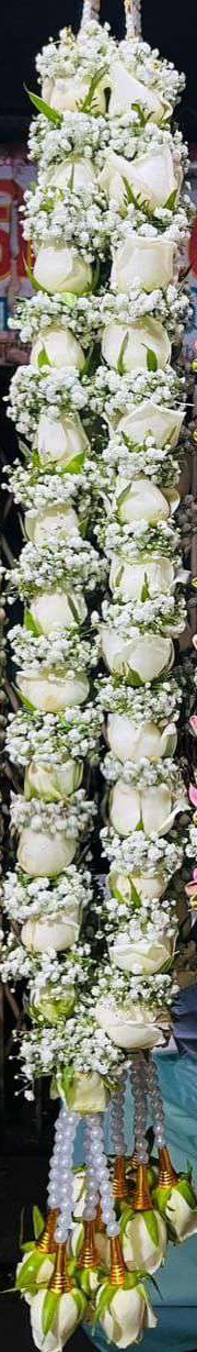 White rose garland wrapped in baby's breath, with pearl strands and gold-cone white rose tassels.