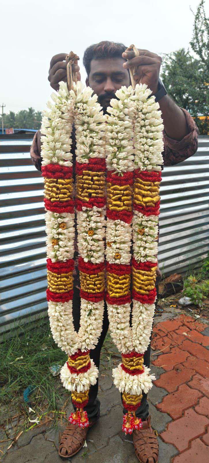Pair of tuberose garlands with red and gold bands and white frill tassels.