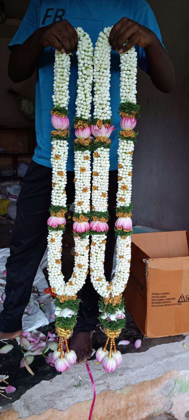 Pair of jasmine garlands with pink lotus spaced along their length and lotus tassels.