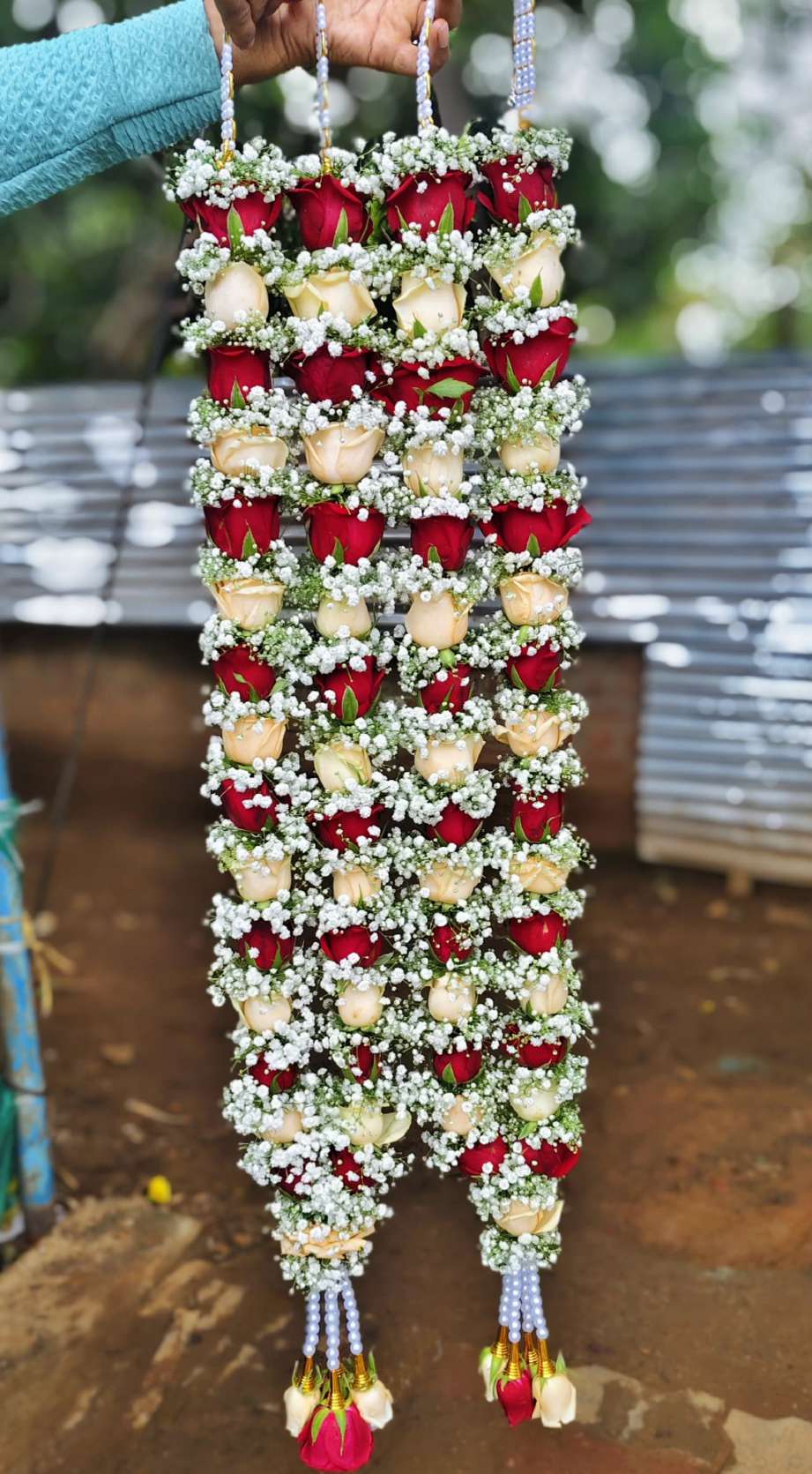 Pair of garlands alternating red and peach roses with baby's breath, pearl hangers and mixed rose tassels.