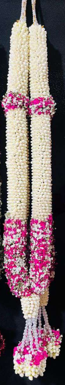 Jasmine garland with magenta baby's breath sections and pearl tassels.