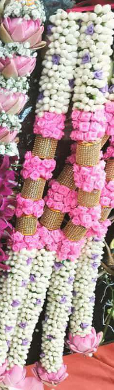 Jasmine garland with purple accents, pink rose bands, gold mesh sections and pink lotus ends.