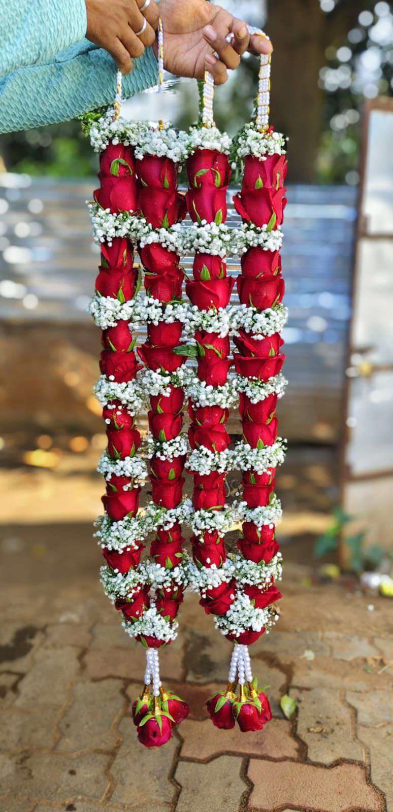 Pair of slim red rose garlands with baby's breath rings, pearl hangers and red rose tassels.