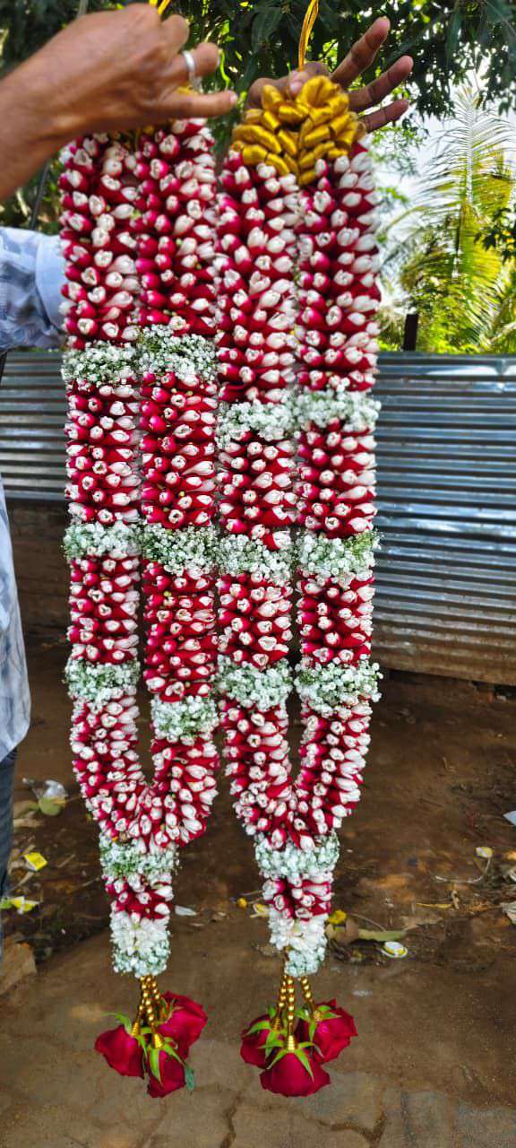 Dense red and white bud garlands with white floral bands and red flower tassels.