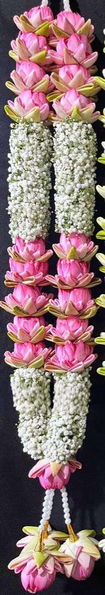 Garland of pink lotus sections between baby's breath sections, with pearl hangers and lotus tassels.
