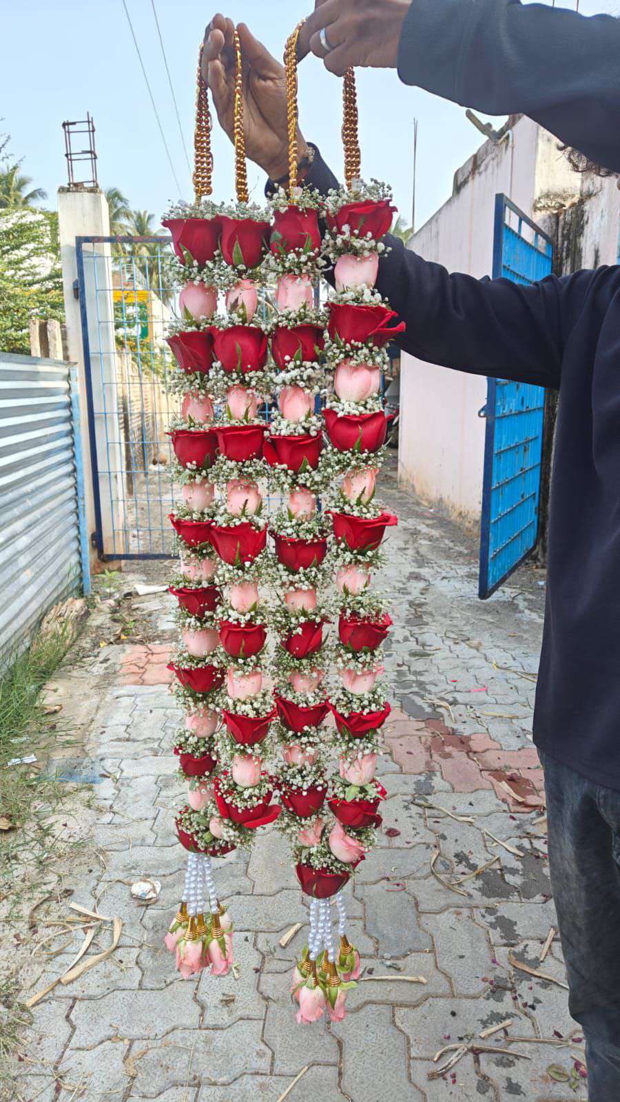 Pair of garlands alternating red and blush roses, with gold bead hangers and pale pink rose tassels.